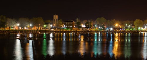 夜间水域附近小镇的风景摄影 · 免费素材图片