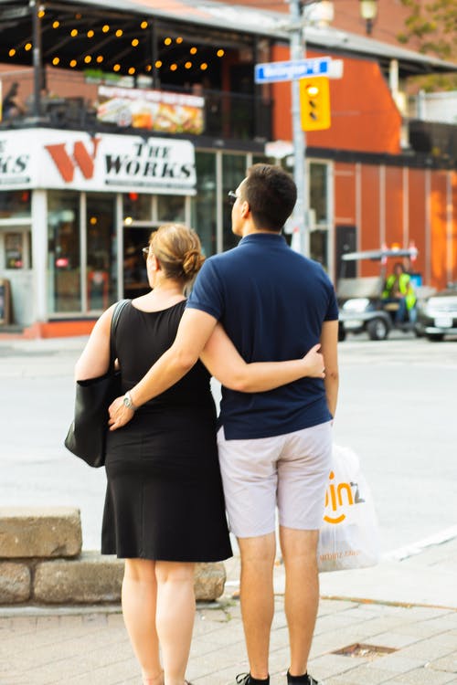 匿名夫妇在城市街道上拥抱 · 免费素材图片