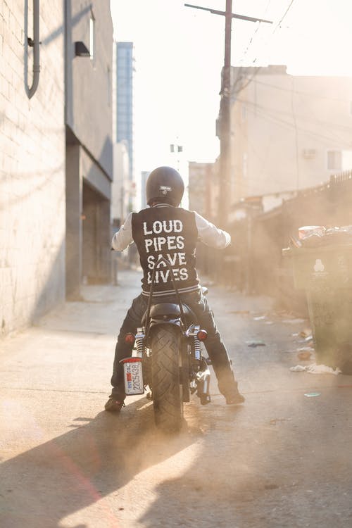 穿黑色和白色夹克骑在摩托车上的男人 · 免费素材图片