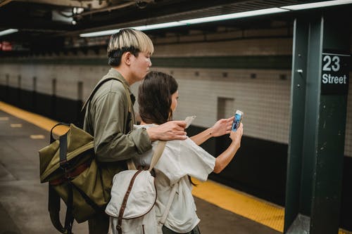 民族小两口在地铁站上采取自拍照 · 免费素材图片