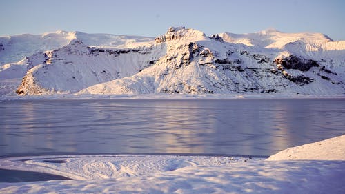 水域附近的白雪覆盖的山脉 · 免费素材图片