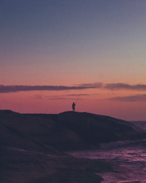 日落时站在岛上的人 · 免费素材图片
