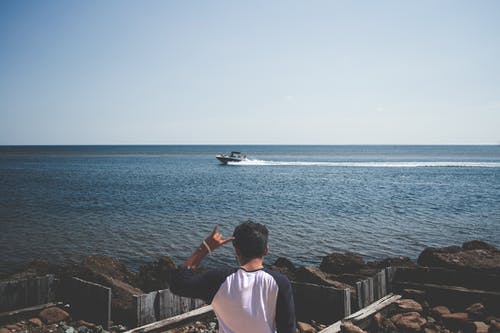 在海边穿蓝色和白色的t恤的男人 · 免费素材图片