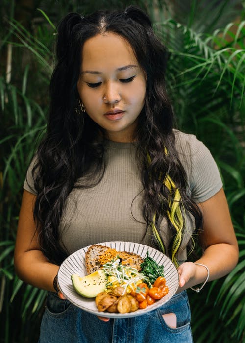 拿着白色陶瓷板与食物的白船员脖子t恤的女孩 · 免费素材图片