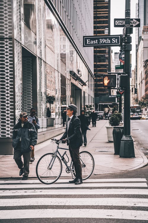 人站在人行横道上的灰色自行车旁边的浅焦点照片 · 免费素材图片