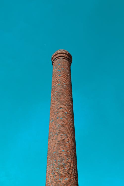 平静的蓝天下的棕色塔的低角度摄影 · 免费素材图片