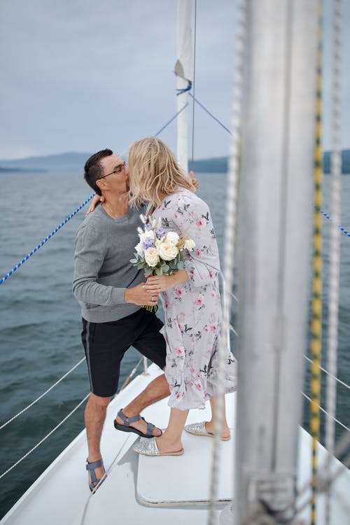 不可识别的女人在旅途中亲吻游艇上的男朋友 · 免费素材图片