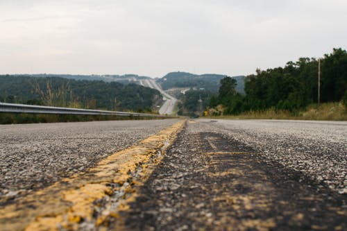 白天，绿树环绕的公路 · 免费素材图片