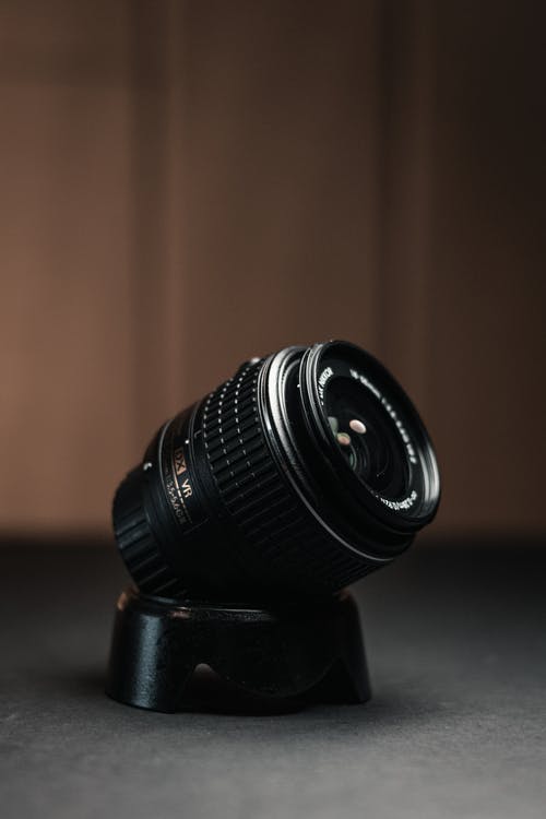 棕色木制的桌子上的黑色相机镜头 · 免费素材图片