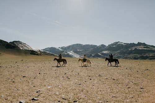 在沙漠对山上骑马的人 · 免费素材图片