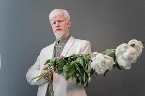自信的白化男人手里拿着花 · 免费素材图片