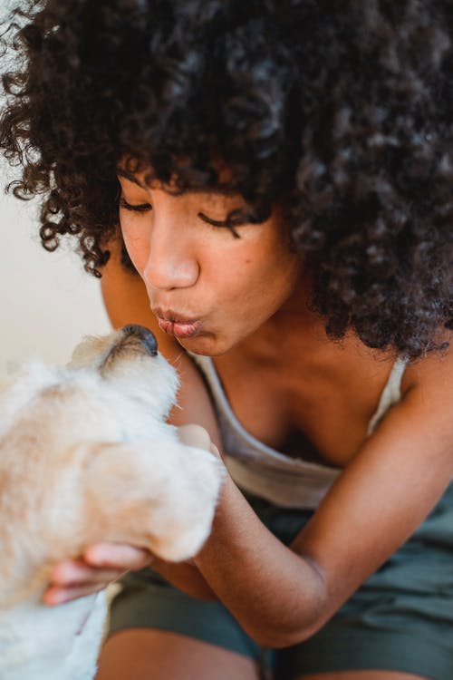 作物族裔女人亲吻可爱的狗 · 免费素材图片