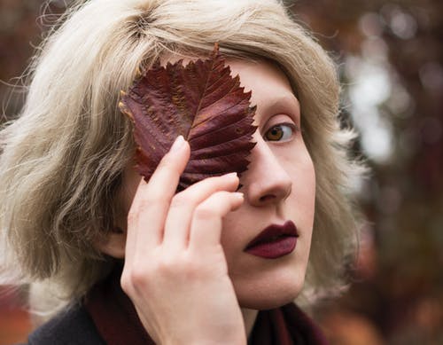 女人覆盖脸与叶的浅焦点摄影 · 免费素材图片