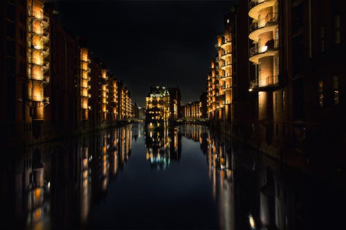 夜间建筑物在水面上的倒影 · 免费素材图片