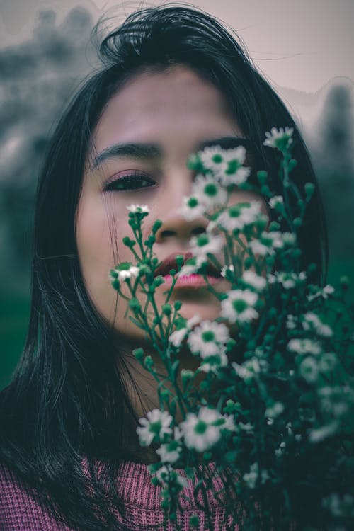 女人盖白色和绿色的花 · 免费素材图片