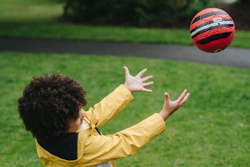 细心的黑人男孩接球 · 免费素材图片