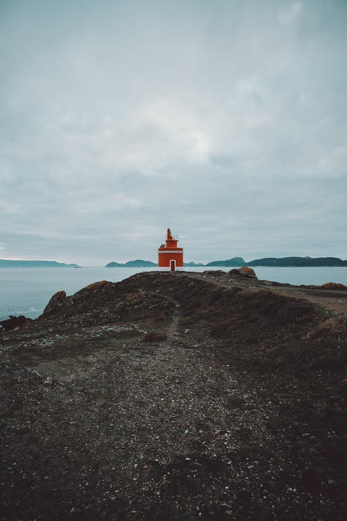 多云的天空下海附近的灯塔 · 免费素材图片