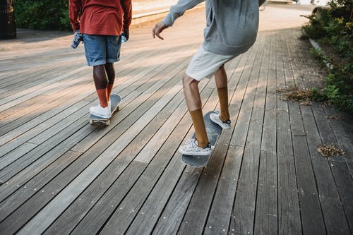 活跃的男人，在木质表面上骑滑板 · 免费素材图片