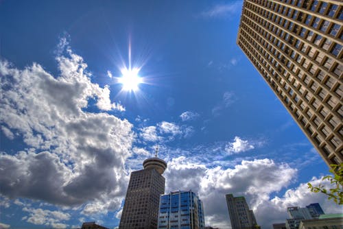 白天在白色和灰色多云的蓝天下的摩天大楼的低角度摄影 · 免费素材图片