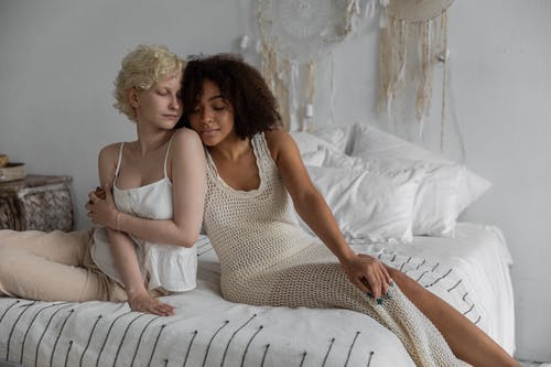 宁静的多种族女同性恋夫妇在舒适的床上拥抱 · 免费素材图片