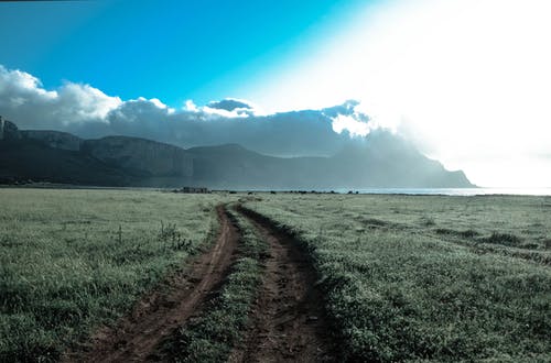 在多云的蓝天下布朗山旁边的绿草田 · 免费素材图片