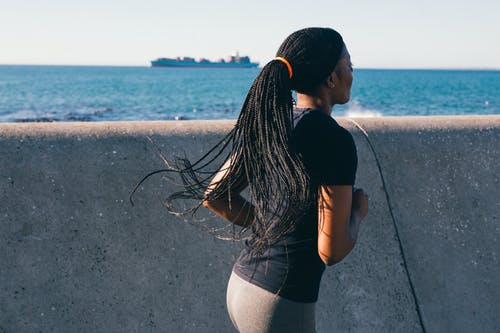 在海堤附近奔跑的女人的照片 · 免费素材图片