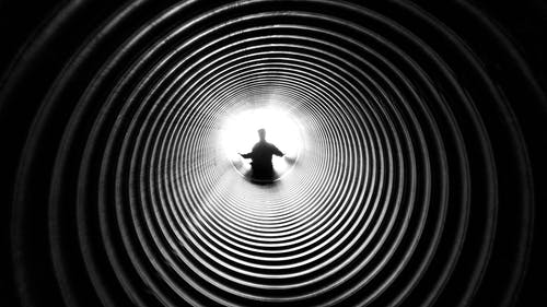 隧道尽头的人的灰度摄影 · 免费素材图片