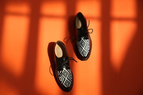 黑色皮鞋橙色背景上的照片 · 免费素材图片
