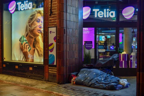 在玻璃窗附近的人行道上睡觉的人 · 免费素材图片
