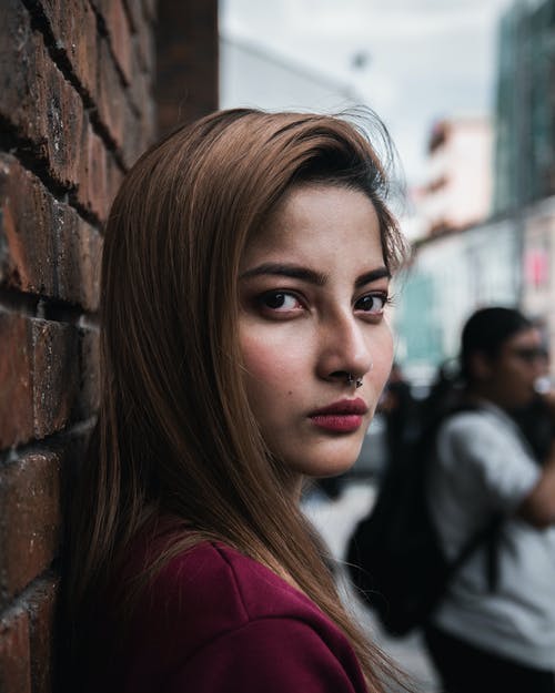 女人靠在墙上的特写照片 · 免费素材图片