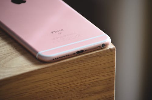 玫瑰金iphone 6s棕色木制表面 · 免费素材图片