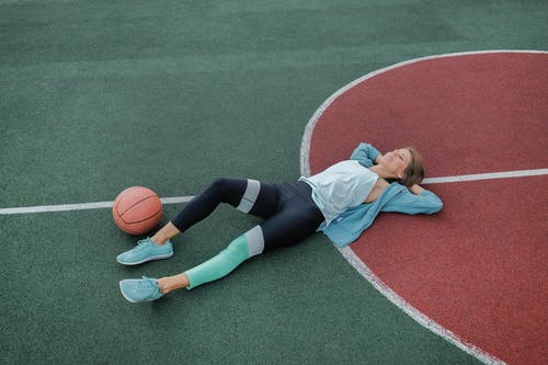 运动后与篮球运动场上休息的女运动员 · 免费素材图片