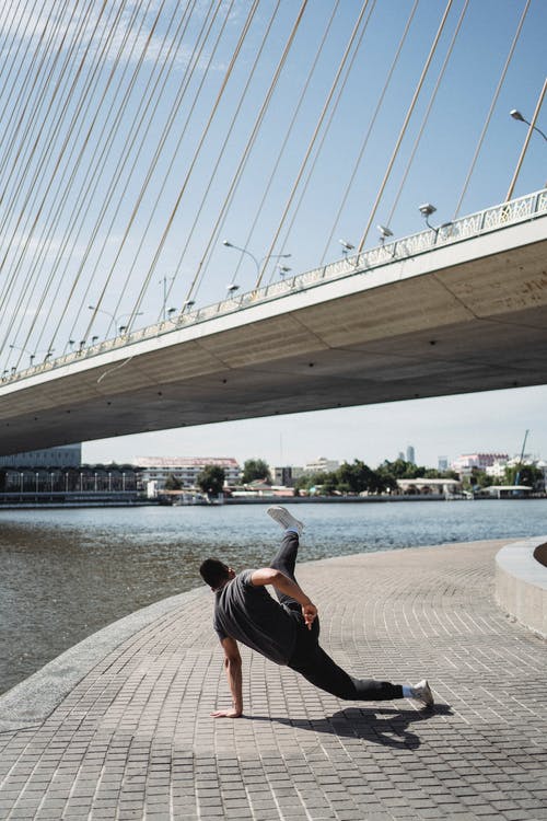 坚强的人，在河边的堤岸上霹雳舞 · 免费素材图片