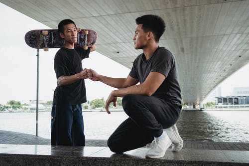 年轻的朋友们在城市桥梁下的长廊上给拳头撞 · 免费素材图片