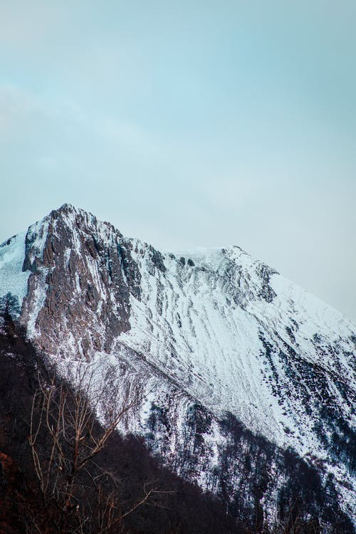 多云的天空下的积雪的山 · 免费素材图片