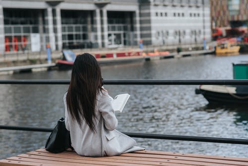 女人花在书上河岸休闲 · 免费素材图片