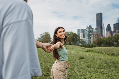 浪漫的年轻民族情侣牵着手在城市绿色公园 · 免费素材图片
