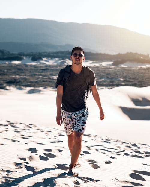 赤脚走在沙滩上的人 · 免费素材图片