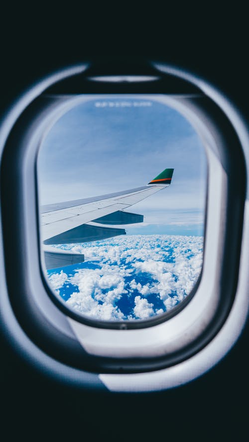 飞机机翼和云层的飞机窗口视图 · 免费素材图片