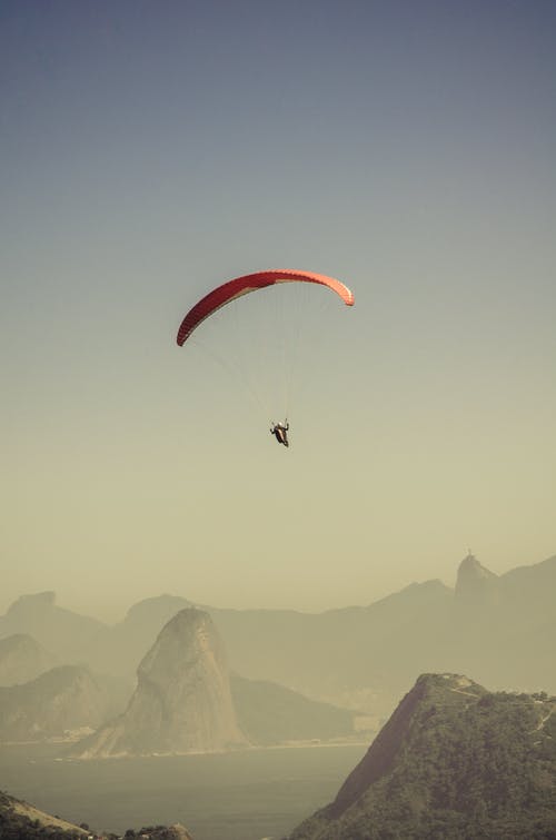 降落伞滑翔在山上的人 · 免费素材图片
