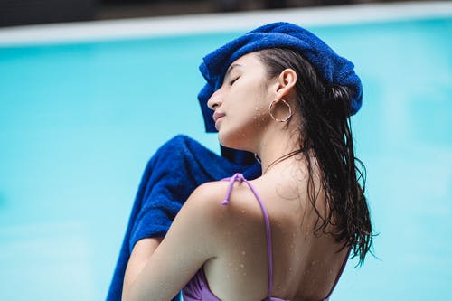 比基尼泳装在游泳池附近休息的性感女士 · 免费素材图片
