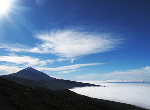 Dayitme在蓝色和白色的天空下的棕色混凝土山 · 免费素材图片