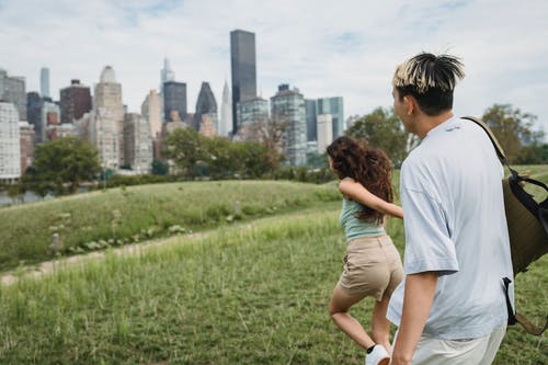 匿名快乐夫妇手牵着手，在城市公园中运行 · 免费素材图片