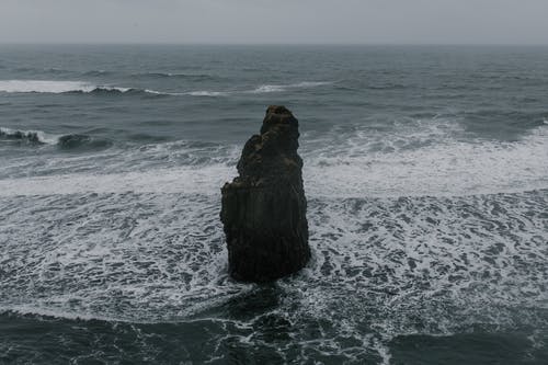 泡沫浅海中的粗糙岩石 · 免费素材图片