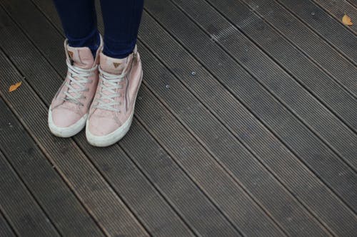 穿着粉红色和白色高帮运动鞋的人 · 免费素材图片