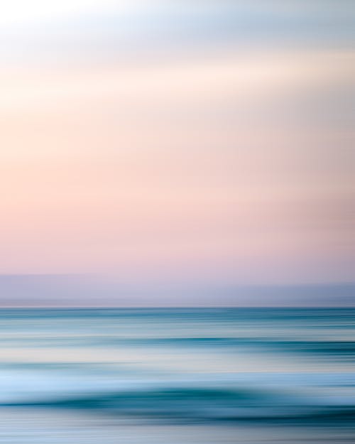 浅粉红色的天空下的海洋的壮丽景色 · 免费素材图片