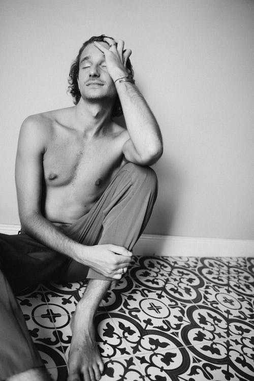 裸照男子坐在床上 · 免费素材图片