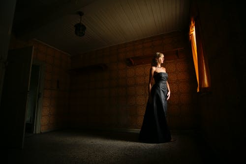 在房间里穿着黑裙子的女人的摄影 · 免费素材图片
