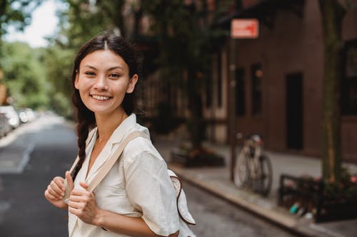 站立在城市街道上的微笑的种族妇女 · 免费素材图片