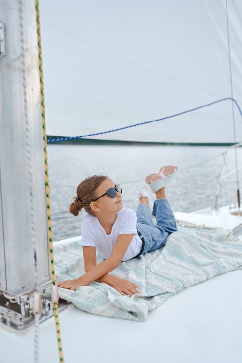 小女孩在海中的帆船上休息 · 免费素材图片
